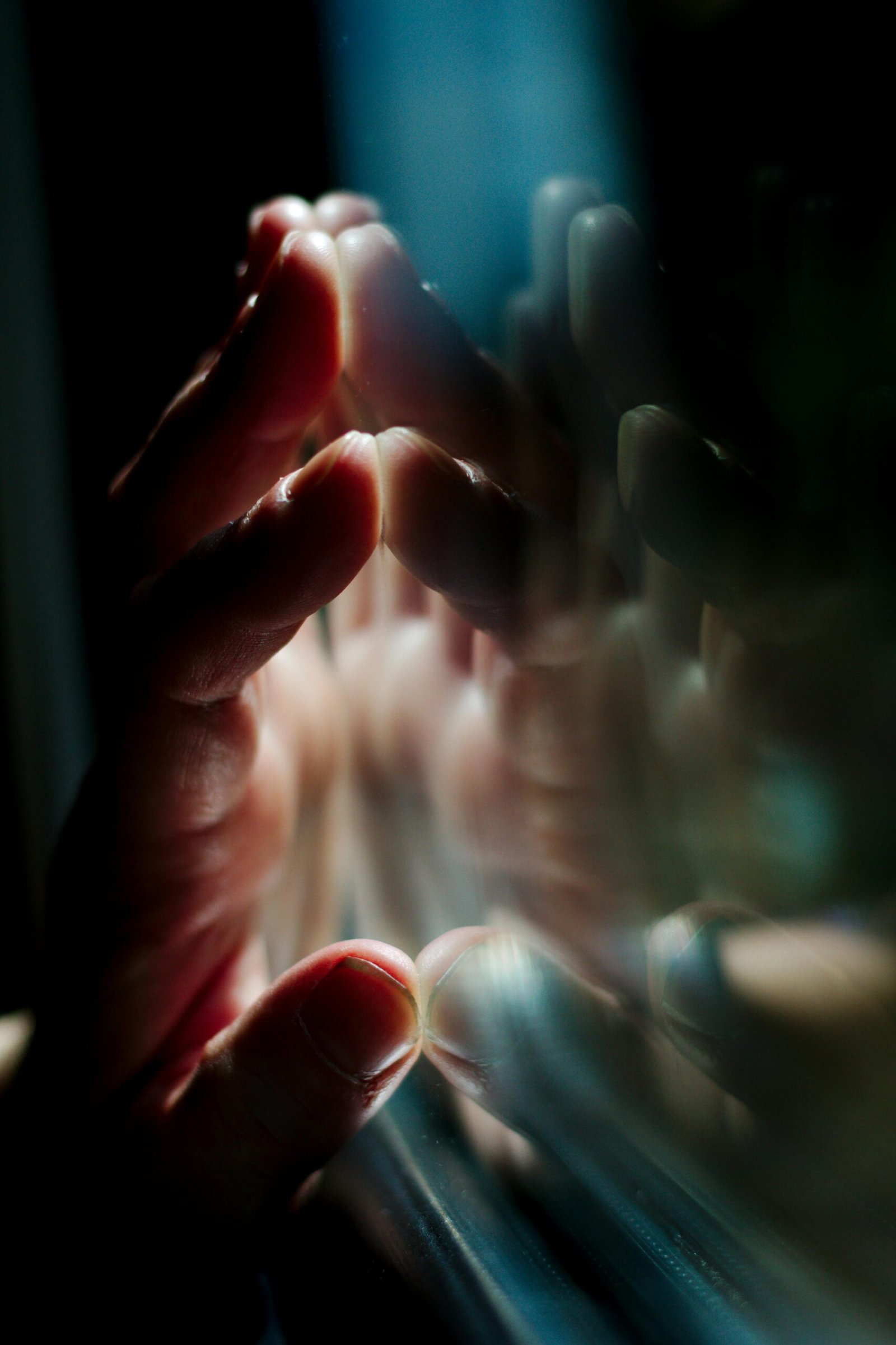 pexels-photo-159333-159333 A hand pressing against a glass surface with vivid reflections, creating a moody atmosphere.
